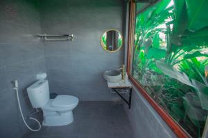 a bathroom with a white toilet and a mirror at Đồi Gió Retreat in Hanoi