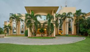 a building with palm trees in front of a playground at Flora Airport Hotel and Convention Centre Kochi in Nedumbassery