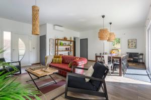 a living room with a red couch and a table at MAISON EOLE in Villeurbanne
