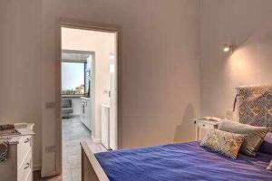 1 dormitorio con 1 cama azul y puerta en Sorrento Capo Apartments by Gocce en Sorrento