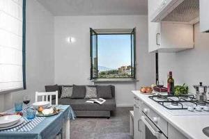 cocina y sala de estar con sofá en Sorrento Capo Apartments by Gocce en Sorrento
