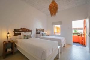 a bedroom with two beds and a chandelier at The Room Padang-Padang in Uluwatu