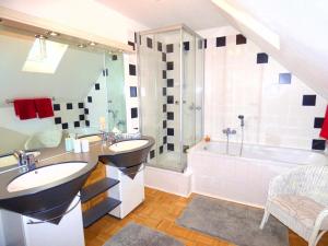 ein Badezimmer mit zwei Waschbecken und einer Badewanne in der Unterkunft Ferienhaus Old Winery in Briedel