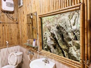 a bathroom with a toilet and a sink and a window at Ham Rong Bungalow in Xuân Sơn