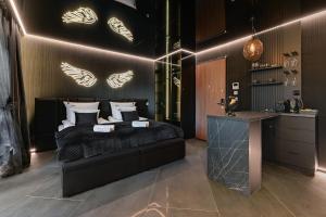 a bedroom with a black bed and a kitchen at Hollywood Jacuzzi Suite by Downtown Apartments in Gdańsk
