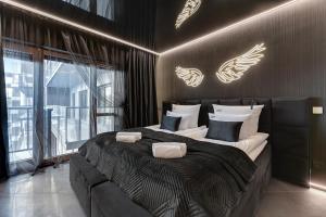 a bedroom with a large bed with lights on the wall at Hollywood Jacuzzi Suite by Downtown Apartments in Gdańsk