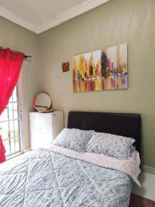 Un dormitorio con una cama y un cuadro en la pared. en Bukit Villa, en Brinchang