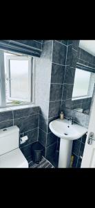 ein Badezimmer mit einem weißen Waschbecken und einem WC in der Unterkunft Master room in Bristol