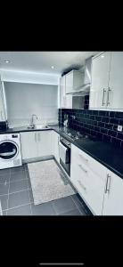 a kitchen with white cabinets and a sink and a stove at Master room in Bristol