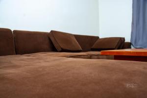 a brown couch in a living room with a table at REAL HOME 3 in Jinja
