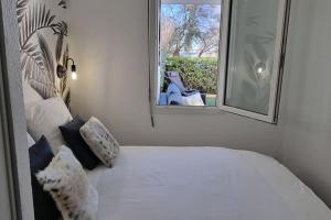 a bedroom with a bed with a mirror and a window at Superbe Appartement déco, Sur la plage, vue mer, 2 chambres, refait à neuf, Climatisé, Parking privé, Piscine in Sète