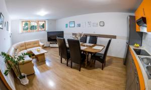 a dining room and living room with a table and chairs at Zimzeleni Apartments in Zreče