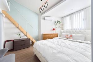 a bedroom with a white bed and a staircase at Seochon Secret Cave House in Seoul