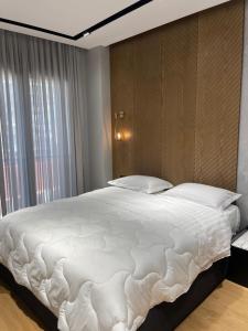a large white bed in a room with a window at Tirana LUX Apartments in Tirana