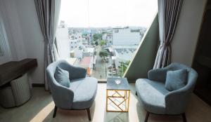 a living room with two chairs and a large window at Eden Hotel in Ho Chi Minh City