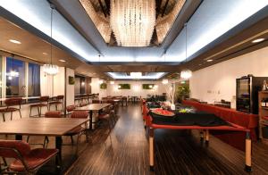 a restaurant with tables and chairs and a chandelier at 朝里川温泉ホテル in Otaru