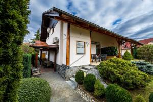 ein Haus mit einem Garten mit Büschen und Bäumen in der Unterkunft Zimzeleni Apartments in Zreče