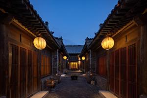 an alley with wooden buildings with lights on them at Jing's Residence Pingyao in Pingyao