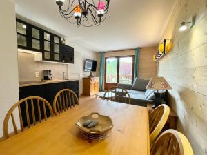 a living room and kitchen with a table and a couch at Appartement Flumet, 3 pièces, 6 personnes - FR-1-505-111 in Flumet
