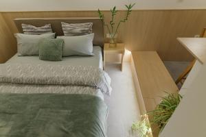 Dormitorio pequeño con cama y mesa en Green and grey loft 2, en Alexandroupoli