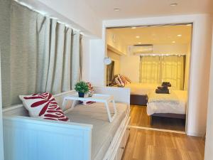 1 dormitorio con 2 camas y ventana con mesa en JUN-shinjuku 4F, en Tokio