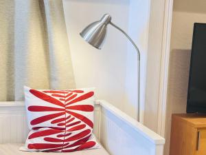 una almohada roja y blanca junto a una lámpara en JUN-shinjuku 4F, en Tokio