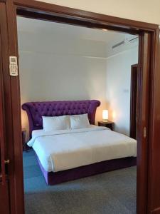 a bedroom with a large bed with a purple headboard at Vacation Suites at Times Square KL in Kuala Lumpur