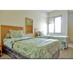 een slaapkamer met 2 bedden en een spiegel bij OYO Life 93383 Wisma Kencana Puteri in Depok