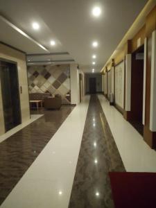 a hallway of a building with a long floor and a couch at MNR Resort in Pipariā