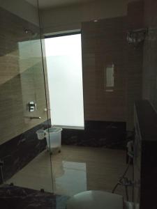 a bathroom with a toilet and a glass shower at MNR Resort in Pipariā
