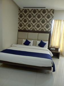 a bedroom with a large bed with blue pillows at MNR Resort in Pipariā