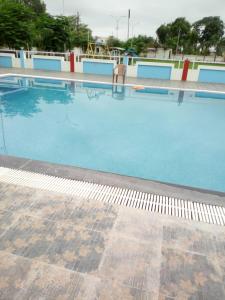 una gran piscina azul con una silla. en MNR Resort en Pipariā
