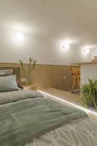 Un dormitorio con 2 camas y una mesa con plantas. en Green and grey loft 2, en Alexandroupoli