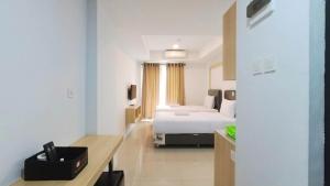 um quarto de hotel com uma cama e uma secretária em Brand New Studio at De Prima Apartment Medan By Travelio em Medan