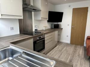 a kitchen with a sink and a stove top oven at Cosy 1 Bedroom Apartment In Cardiff in Cardiff