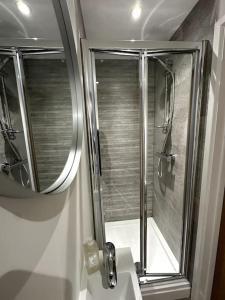 a bathroom with a shower and a sink with a mirror at Cosy 1 Bedroom Apartment In Cardiff in Cardiff