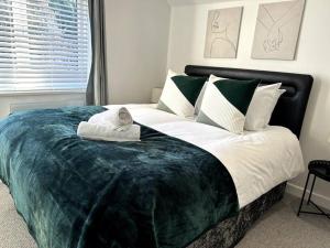 a bedroom with a large bed with green and white pillows at Cosy 1 Bedroom Apartment In Cardiff in Cardiff