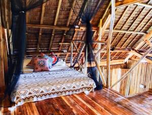 Cama en habitación con suelo de madera en Barya Lang Villa- Native villa with jeepney room en El Nido