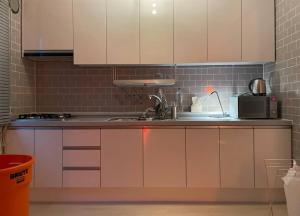 a kitchen with white cabinets and a microwave at Aufn Orange Bulb in Seoul