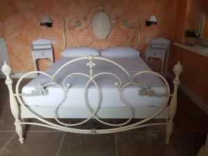 a white bed with a metal frame in a bedroom at Country House Il Sassòne in Camerano