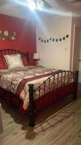 um quarto com uma cama com uma parede vermelha em City Center Home ONeal lane em Baton Rouge