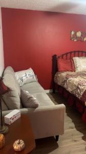 um quarto com duas camas e uma parede vermelha em City Center Home ONeal lane em Baton Rouge