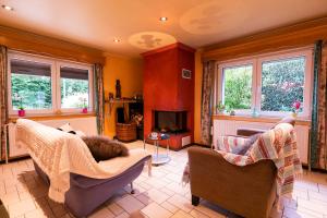 a living room with two chairs and a fireplace at Orval16 in Villers-devant-Orval