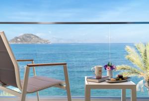 una habitación con una mesa y una silla y el océano en Arin Resort Bodrum, en Turgutreis