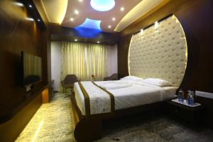 um quarto com uma cama grande e uma televisão em Hotel White Rock em Bangalore