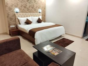a bedroom with a bed with a table and a couch at MOUNT VIEW HOTEL in Ajmer