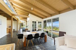 a dining room and living room with a table and chairs at 'Clifftop Cocoon' Swing into Scenic Sea Views in San Remo