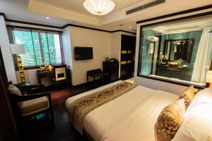 Cette chambre comprend un lit et une grande fenêtre. dans l'établissement Golden Lotus Luxury Hotel, à Hanoï