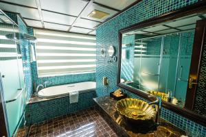 a bathroom with a tub and a toilet and a sink at Golden Lotus Luxury Hotel in Hanoi