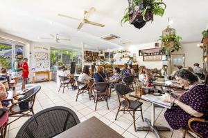 a group of people sitting at tables in a restaurant at 'The Botanica' A Triple-apartment Residence in Nightcliff in Darwin